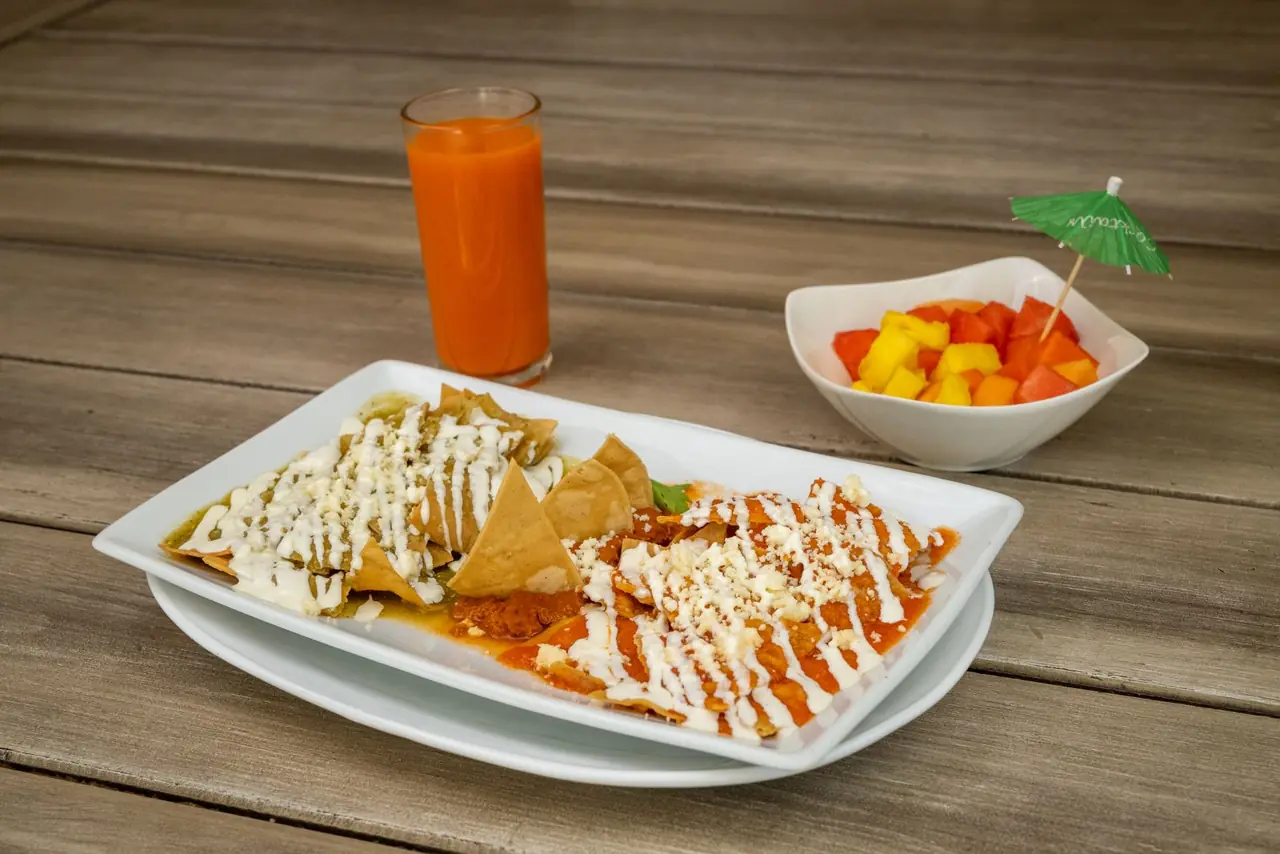 Chilaquiles plated with a glass of juice