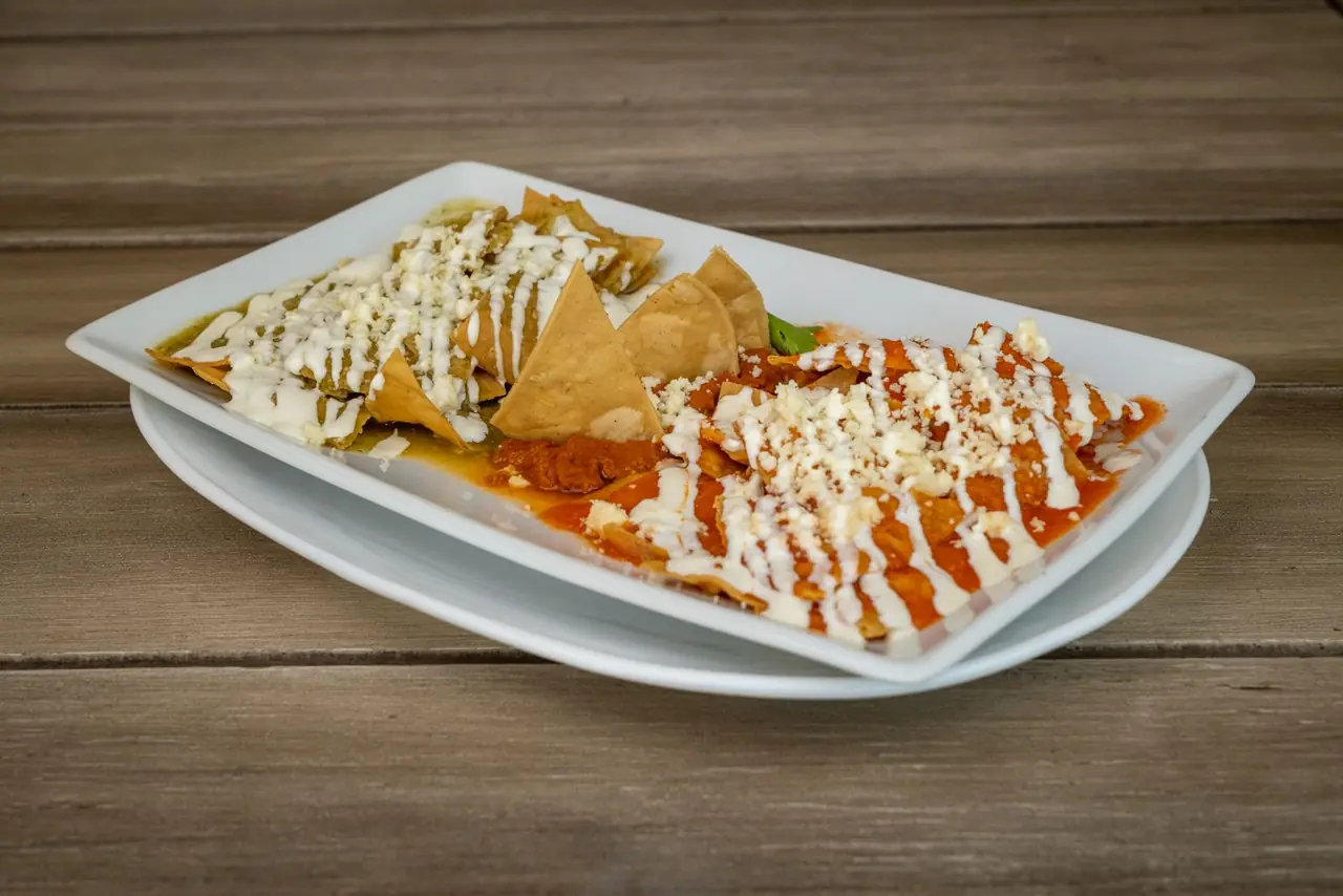 Chilaquiles topped with crema and cheese